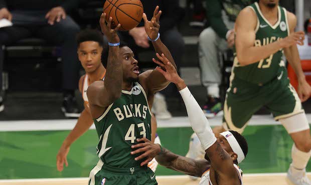 Thanasis Antetokounmpo #43 of the Milwaukee Bucks goes up for a shot against Torrey Craig #12 of th...