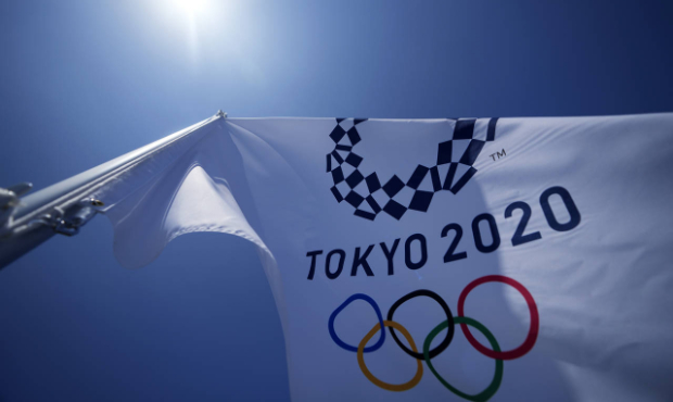 A Tokyo 2020 Olympic flag flies over the top of the bleachers at Ariake Tennis Center, Monday, July...