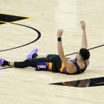 Phoenix Suns guard Devin Booker lies on the court after an offensive foul called against him during the second half of Game 1 of basketball's NBA Finals against the Milwaukee Bucks, Tuesday, July 6, 2021, in Phoenix. (AP Photo/Matt York)