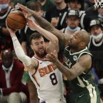 Phoenix Suns' Frank Kaminsky (8) is fouled by Milwaukee Bucks' P.J. Tucker during the second half of Game 3 of basketball's NBA Finals, Sunday, July 11, 2021, in Milwaukee. (AP Photo/Aaron Gash)