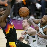 Phoenix Suns center Deandre Ayton, left, jumps for the ball next to Milwaukee Bucks guard Pat Connaughton, middle, and forward P.J. Tucker during the first half of Game 2 of basketball's NBA Finals, Thursday, July 8, 2021, in Phoenix. (AP Photo/Ross D. Franklin)