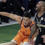 Phoenix Suns guard Devin Booker (1) works the ball against Milwaukee Bucks guard Bryn Forbes (7) during the first half of Game 6 of basketball's NBA Finals Tuesday, July 20, 2021, in Milwaukee. (AP Photo/Aaron Gash)