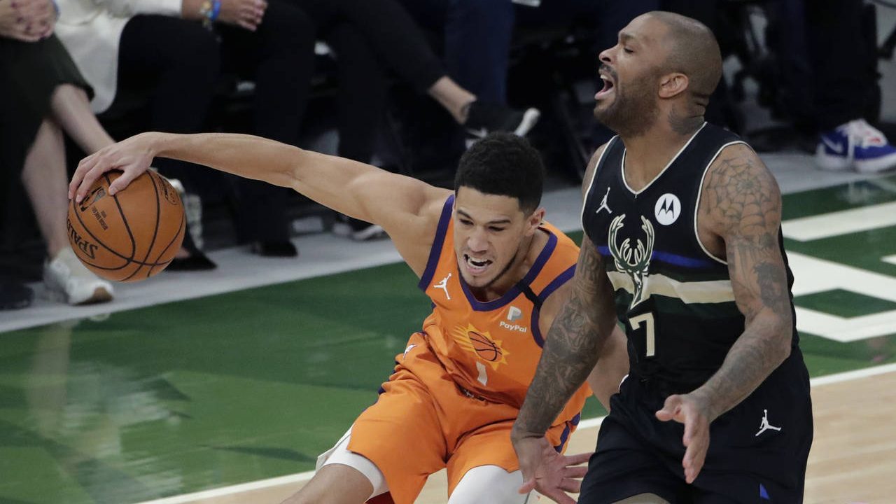 Phoenix Suns guard Devin Booker (1) works the ball against Milwaukee Bucks guard Bryn Forbes (7) du...