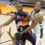 Phoenix Suns guard Chris Paul (3) passes the ball while defended by Milwaukee Bucks forward P.J. Tucker during the first half of Game 2 of basketball's NBA Finals, Thursday, July 8, 2021, in Phoenix. (AP Photo/Matt York)