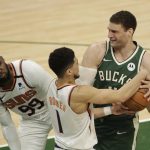 Milwaukee Bucks' Brook Lopez drives to the basket against Phoenix Suns' Devin Booker (1) and Jae Crowder (99) during the second half of Game 3 of basketball's NBA Finals, Sunday, July 11, 2021, in Milwaukee. (AP Photo/Aaron Gash)