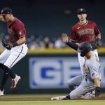 Arizona Diamondbacks second baseman Josh Rojas (10) jumps off of second base after forcing out Pittsburgh Pirates' Jared Oliva, right, as Diamondbacks shortstop Nick Ahmed (13) looks on during the second inning of a baseball game, Wednesday, July 21, 2021, in Phoenix. (AP Photo/Ross D. Franklin)