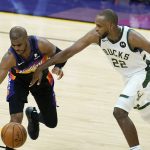 Phoenix Suns guard Chris Paul, left, has the ball tipped away by Milwaukee Bucks forward Khris Middleton (22) during the second half of Game 1 of basketball's NBA Finals, Tuesday, July 6, 2021, in Phoenix. The Suns defeated the Bucks 118-105. (AP Photo/Ross D. Franklin)