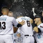 Arizona Diamondbacks' David Peralta (6) is doused with water as he celebrates with Nick Ahmed (13), Dalton Varsho (12) and others after being hit by a pitch with the bases loaded to give the team a 4-3 win over the Colorado Rockies in a baseball game Tuesday, July 6, 2021, in Phoenix. (AP Photo/Ralph Freso)