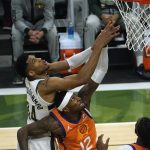 Milwaukee Bucks forward Giannis Antetokounmpo (34) fights for a rebound with Phoenix Suns forward Torrey Craig (12) during the first half of Game 4 of basketball's NBA Finals in Milwaukee, Wednesday, July 14, 2021. (AP Photo/Paul Sancya)