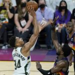 Milwaukee Bucks forward Giannis Antetokounmpo (34) shoots against Phoenix Suns center Deandre Ayton during the first half of Game 2 of basketball's NBA Finals, Thursday, July 8, 2021, in Phoenix. (AP Photo/Ross D. Franklin)