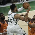 Milwaukee Bucks forward Giannis Antetokounmpo (34) drives to the basket between Phoenix Suns center Deandre Ayton (22) and guard Chris Paul (3) during the second half of Game 4 of basketball's NBA Finals Wednesday, July 14, 2021, in Milwaukee. (AP Photo/Aaron Gash)