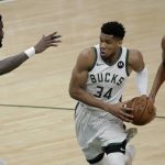 Milwaukee Bucks forward Giannis Antetokounmpo (34) drives to the basket between Phoenix Suns center Deandre Ayton, left, and forward Mikal Bridges (25) during the second half of Game 4 of basketball's NBA Finals Wednesday, July 14, 2021, in Milwaukee. (AP Photo/Aaron Gash)
