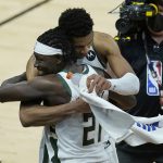 Milwaukee Bucks forward Giannis Antetokounmpo, top, celebrates with guard Jrue Holiday (21) after the Bucks defeated the Phoenix Suns in Game 5 of basketball's NBA Finals, Saturday, July 17, 2021, in Phoenix. (AP Photo/Ross D. Franklin)