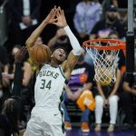 Milwaukee Bucks forward Giannis Antetokounmpo (34) gets fouled by Phoenix Suns forward Jae Crowder, second from left, as Suns forward Mikal Bridges, left, looks on during the first half of Game 1 of basketball's NBA Finals, Tuesday, July 6, 2021, in Phoenix. (AP Photo/Ross D. Franklin)