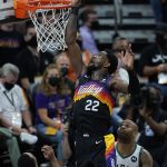 Phoenix Suns center Deandre Ayton (22) shoots over Milwaukee Bucks guard Jeff Teague, left, and forward P.J. Tucker during the first half of Game 5 of basketball's NBA Finals, Saturday, July 17, 2021, in Phoenix. (AP Photo/Ross D. Franklin)