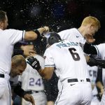 Arizona Diamondbacks' David Peralta (6) is doused with water as he celebrates with Stephen Vogt (21), Bryan Holiday (28) and others after getting hit with a pitch with the bases loaded to drive in the winning run against the Colorado Rockies during the ninth inning of a baseball game Tuesday, July 6, 2021, in Phoenix. (AP Photo/Ralph Freso)