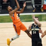 Phoenix Suns forward Mikal Bridges (25) shoots over Milwaukee Bucks guard Pat Connaughton (24) during the first half of Game 6 of basketball's NBA Finals in Milwaukee, Tuesday, July 20, 2021. (AP Photo/Paul Sancya)
