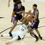 Phoenix Suns guard Cameron Payne, right, steals the ball from Milwaukee Bucks forward Giannis Antetokounmpo (34) as forward Cameron Johnson (23) looks on during the second half of Game 1 of basketball's NBA Finals, Tuesday, July 6, 2021, in Phoenix. (AP Photo/Matt York)