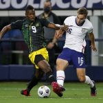 Jamaica forward Cory Burke (9) and United States defender James Sands (16) compete for control of the ball in the first half of a 2021 CONCACAF Gold Cup quarterfinals soccer match, Sunday, July 25, 2021, in Arlington, Texas. (AP Photo/Brandon Wade)
