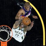 Milwaukee Bucks forward P.J. Tucker (17) pulls down a rebound as Phoenix Suns guard Chris Paul looks on during the first half of Game 2 of basketball's NBA Finals, Thursday, July 8, 2021, in Phoenix. (AP Photo/Ross D. Franklin, pool)