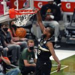 Milwaukee Bucks forward Khris Middleton (22) slam dunks during the first half of Game 6 of basketball's NBA Finals against the Phoenix Suns in Milwaukee, Tuesday, July 20, 2021. (AP Photo/Paul Sancya)