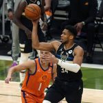 Milwaukee Bucks forward Giannis Antetokounmpo (34) moves towards the basket against Phoenix Suns guard Devin Booker (1) during the first half of Game 6 of basketball's NBA Finals in Milwaukee, Tuesday, July 20, 2021. (AP Photo/Paul Sancya)