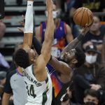 Phoenix Suns center Deandre Ayton, right, shoots against Milwaukee Bucks forward Giannis Antetokounmpo during the first half of Game 2 of basketball's NBA Finals, Thursday, July 8, 2021, in Phoenix. (AP Photo/Ross D. Franklin)