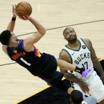 Milwaukee Bucks forward P.J. Tucker (17) reacts as he is called for a foul on Phoenix Suns guard Devin Booker (1) during the first half of Game 1 of basketball's NBA Finals, Tuesday, July 6, 2021, in Phoenix. (AP Photo/Matt York)