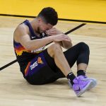 Phoenix Suns guard Devin Booker reacts after contact during the first half of Game 2 of basketball's NBA Finals against the Milwaukee Bucks, Thursday, July 8, 2021, in Phoenix. (AP Photo/Ross D. Franklin)