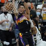 Phoenix Suns guard Devin Booker (1) is fouled by Milwaukee Bucks forward Giannis Antetokounmpo during the first half of Game 5 of basketball's NBA Finals, Saturday, July 17, 2021, in Phoenix. (AP Photo/Ross D. Franklin)