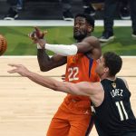 Phoenix Suns center Deandre Ayton (22) and Milwaukee Bucks center Brook Lopez (11) battle for the ball during the first half of Game 6 of basketball's NBA Finals in Milwaukee, Tuesday, July 20, 2021. (AP Photo/Paul Sancya)