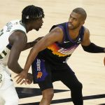 Phoenix Suns guard Chris Paul, right, is defended by Milwaukee Bucks guard Jrue Holiday during the second half of Game 2 of basketball's NBA Finals, Thursday, July 8, 2021, in Phoenix. (AP Photo/Matt York)