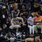 Fans help Milwaukee Bucks guard Pat Connaughton get up during the second half of Game 2 of basketball's NBA Finals between the Phoenix Suns and the Bucks, Thursday, July 8, 2021, in Phoenix. (AP Photo/Ross D. Franklin)