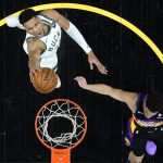 Milwaukee Bucks forward Giannis Antetokounmpo shoots as Phoenix Suns guard Devin Booker, right, defends during the first half of Game 2 of basketball's NBA Finals, Thursday, July 8, 2021, in Phoenix. (AP Photo/Ross D. Franklin, pool)