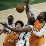 Phoenix Suns forward Jae Crowder (99) blocks a shot by Milwaukee Bucks forward Khris Middleton (22) during the second half of Game 4 of basketball's NBA Finals Wednesday, July 14, 2021, in Milwaukee. (AP Photo/Aaron Gash)