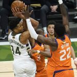 Milwaukee Bucks forward Giannis Antetokounmpo (34) shoots over Phoenix Suns guard Chris Paul (3) and center Deandre Ayton (22) during the second half of Game 4 of basketball's NBA Finals in Milwaukee, Wednesday, July 14, 2021. (AP Photo/Paul Sancya)