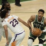 Milwaukee Bucks' Giannis Antetokounmpo (34) looks to shoot past Phoenix Suns' Cameron Johnson (23) and Jae Crowder during the second half of Game 3 of basketball's NBA Finals, Sunday, July 11, 2021, in Milwaukee. (AP Photo/Aaron Gash)