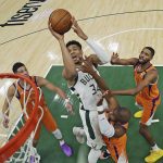 Milwaukee Bucks' Giannis Antetokounmpo (34) shoots over Phoenix Suns' Devin Booker, from left to right, Chris Paul and Mikal Bridges during Game 4 of basketball's NBA Finals, Wednesday, July 14, 2021, in Milwaukee. (Jonathan Daniel/Pool Photo via AP)