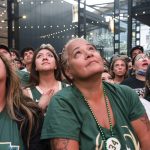 Fans watch television coverage of Game 6 of the NBA basketball finals between the Milwaukee Bucks and the Phoenix Suns on Tuesday, July 20, 2021, in Milwaukee. (AP Photo/Jeffrey Phelps)
