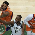 Milwaukee Bucks forward Khris Middleton (22) drives to the basket against Phoenix Suns guard Cameron Payne, left, and Jae Crowder, right, during Game 4 of basketball's NBA Finals in Milwaukee, Wednesday, July 14, 2021. (AP Photo/Paul Sancya, Pool)