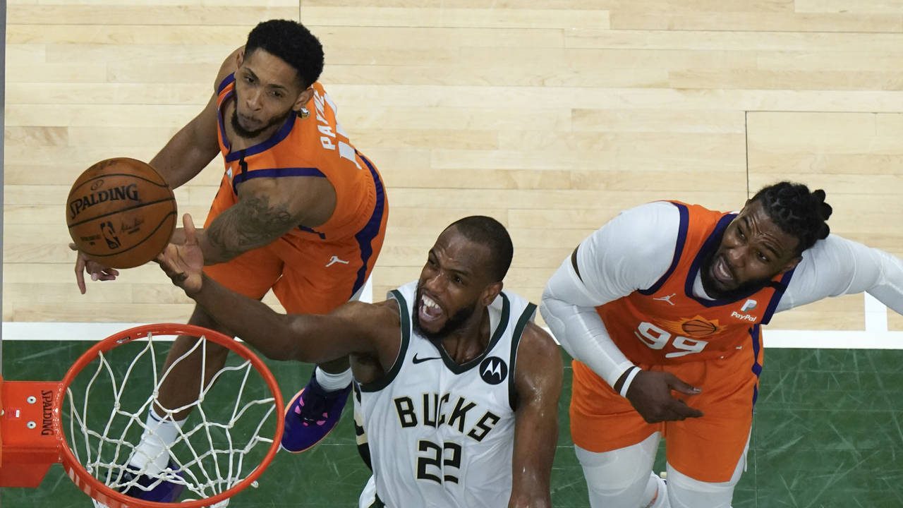 Milwaukee Bucks forward Khris Middleton (22) drives to the basket against Phoenix Suns guard Camero...