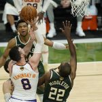 Phoenix Suns' Frank Kaminsky (8) shoots against Milwaukee Bucks' Khris Middleton (22) during the first half of Game 3 of basketball's NBA Finals in Milwaukee, Sunday, July 11, 2021. (AP Photo/Paul Sancya)
