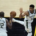 Milwaukee Bucks forward Giannis Antetokounmpo (34) passes the ball to Bucks forward Khris Middleton (22) during the second half of Game 1 of basketball's NBA Finals against the Phoenix Suns, Tuesday, July 6, 2021, in Phoenix. The Suns defeated the Bucks 118-105. (AP Photo/Ross D. Franklin)
