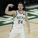 Milwaukee Bucks guard Pat Connaughton (24) celebrates after making a three-point basket during the second half against the Phoenix Suns in Game 4 of basketball's NBA Finals Wednesday, July 14, 2021, in Milwaukee. (AP Photo/Aaron Gash)