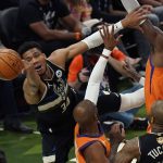 Milwaukee Bucks forward Giannis Antetokounmpo (34) battles under the basket against Phoenix Suns guard Chris Paul, center, and center Deandre Ayton, right, during the first half of Game 6 of basketball's NBA Finals in Milwaukee, Tuesday, July 20, 2021. (AP Photo/Paul Sancya)