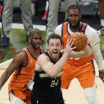 Milwaukee Bucks guard Pat Connaughton (24) looks to pass under pressure from Phoenix Suns guard Chris Paul, left, and forward Jae Crowder during the first half of Game 6 of basketball's NBA Finals in Milwaukee, Tuesday, July 20, 2021. (AP Photo/Paul Sancya)