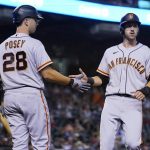 San Francisco Giants' Steven Duggar, right, celebrates his run scored against the Arizona Diamondbacks with teammate Buster Posey (28) during the second inning of a baseball game Friday, July 2, 2021, in Phoenix. (AP Photo/Ross D. Franklin)