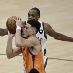 Phoenix Suns guard Devin Booker drives to the basket ahead of Milwaukee Bucks forward Khris Middleton, rear, during the first half of Game 4 of basketball's NBA Finals Wednesday, July 14, 2021, in Milwaukee. (AP Photo/Aaron Gash)