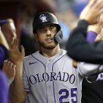 Colorado Rockies' C.J. Cron (25) is congratulated by teammates in the dugout after scoring against the Arizona Diamondbacks during the fifth inning of a baseball game Tuesday, July 6, 2021, in Phoenix. (AP Photo/Ralph Freso)