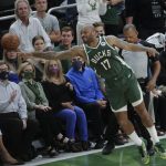 Milwaukee Bucks' P.J. Tucker (17) reaches for the basketball during the first half of Game 3 against the Phoenix Suns, Sunday, July 11, 2021, in Milwaukee. (AP Photo/Aaron Gash)